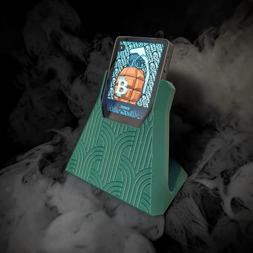 Trezor Safe 7 Dock in teal with Trezor Safe 7 hardware wallet against a dark smoke background