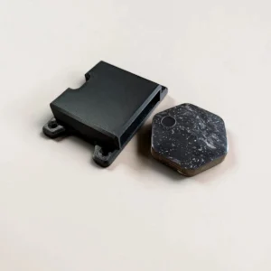 Black CryptoCloaks Bitkey Mount beside a second-generation screen-equipped Bitkey hardware device showing the compatible form factor