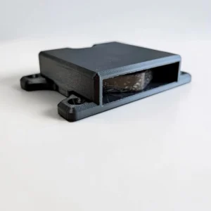 Close front view of black CryptoCloaks mount holding a second-generation Bitkey hardware device with screw mounting tabs visible