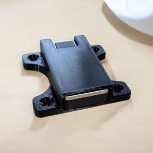 Black Jade Plus mount holding a silver-edged hardware wallet with recessed mounting holes visible