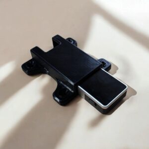 Black CryptoCloaks Jade Plus mount holding a silver-edged hardware wallet with four screw mounting tabs visible